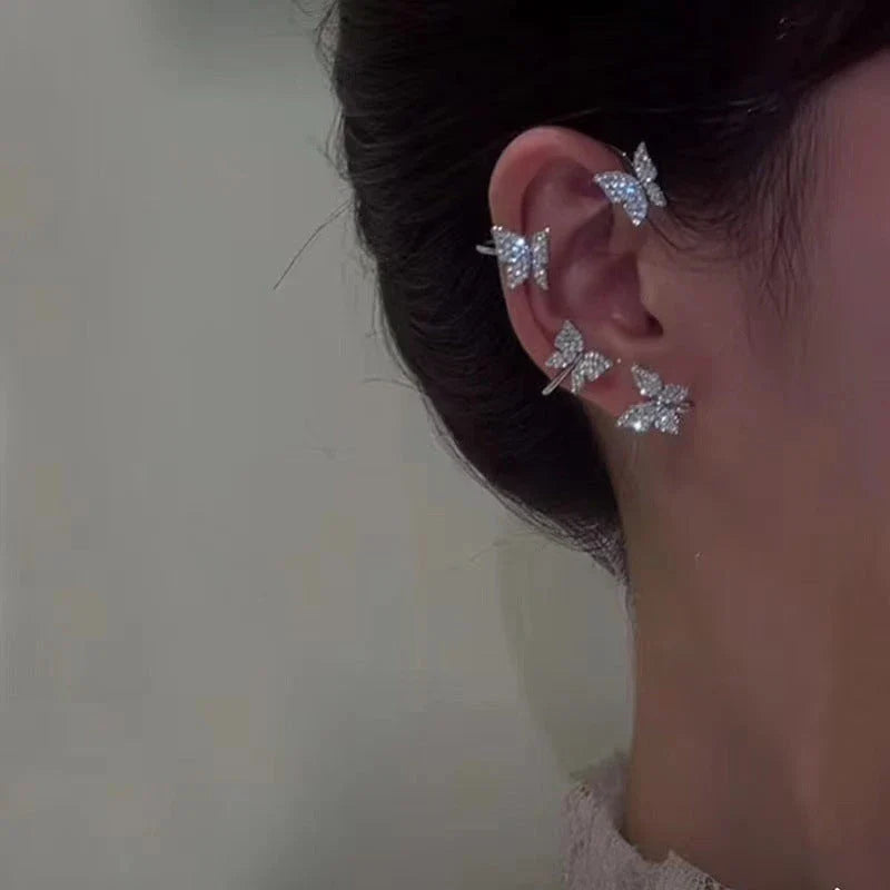 Fashionable butterfly-shaped ear clips in gold and silver tones, showcasing a chic, European-inspired design.
