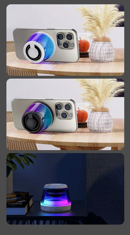 Small white portable Bluetooth speaker with LED light glow on a wooden desk next to a smartphone.