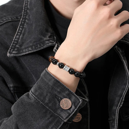 Men's black obsidian prayer wheel bracelet with hand-woven construction and 10mm beads
