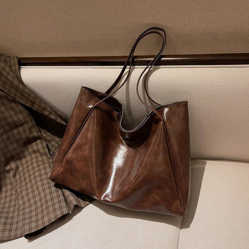 Stylish leather shoulder bag in various colors, including wine red, blue, black, brown, and beige. Showcases a versatile and spacious design for everyday use.