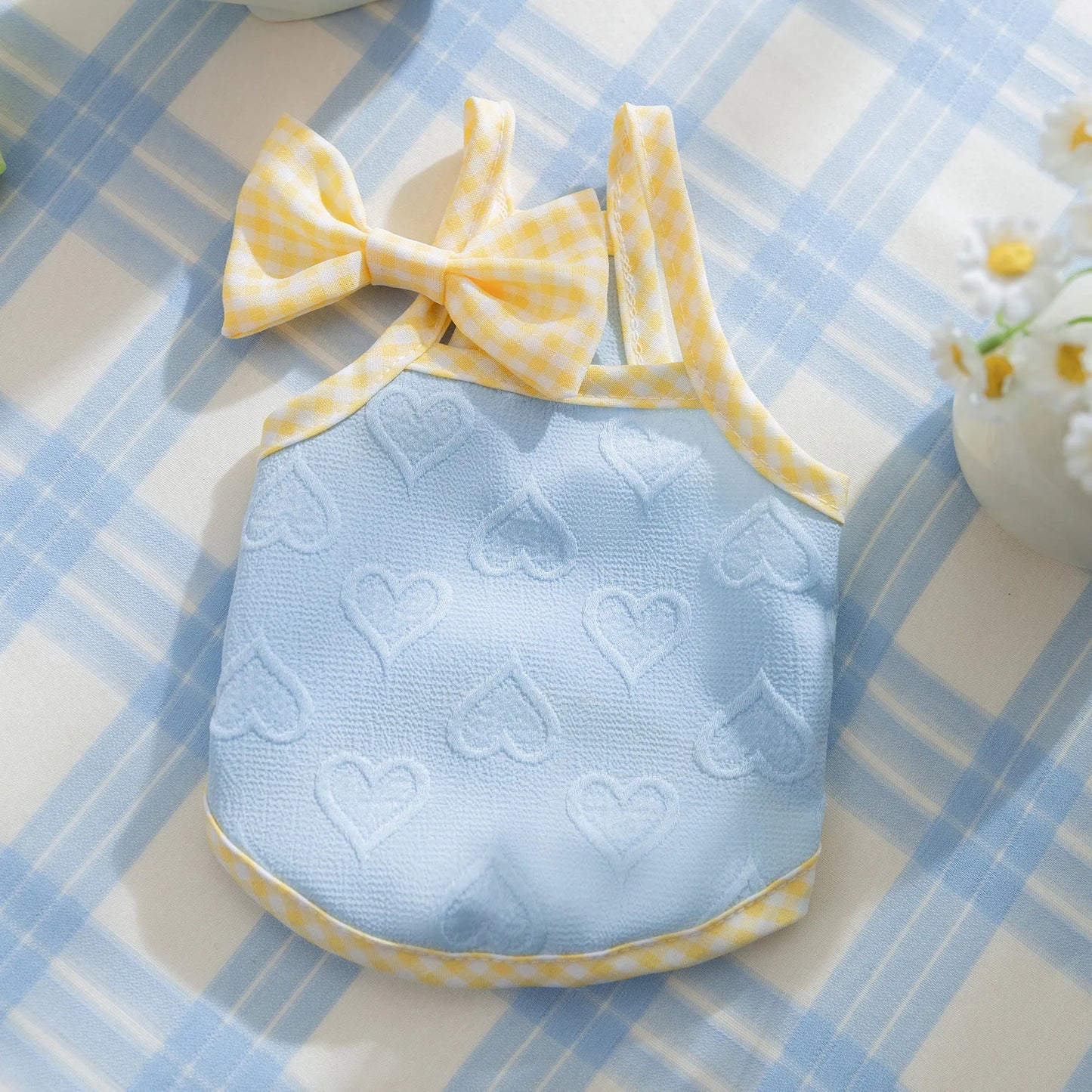 Small dog wearing blue elastic vest with suspenders and bow detail, showing stretch fit