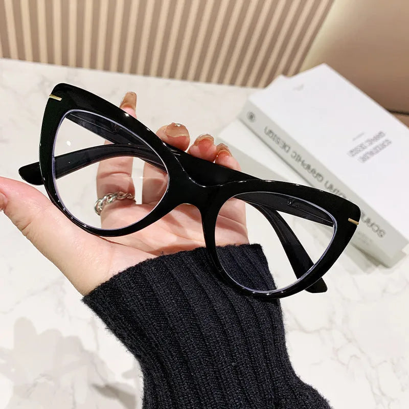 Women's black cat's eye reading glasses with gold dragon and phoenix decorations on the temples.