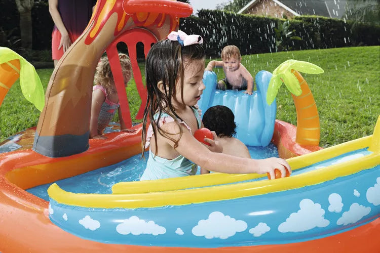 Children playing in an inflatable volcano-shaped pool with sprinkler and toys