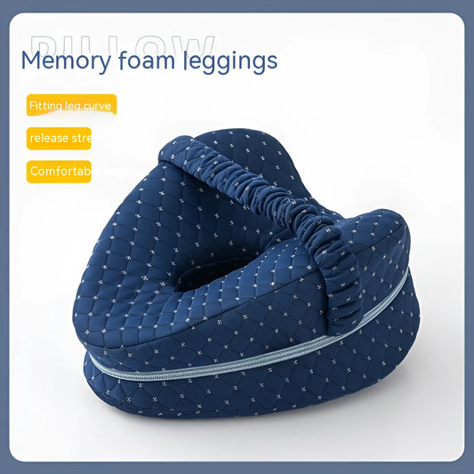 Dark blue jacquard heart-shaped memory foam leg pillow for adults on a bed.
