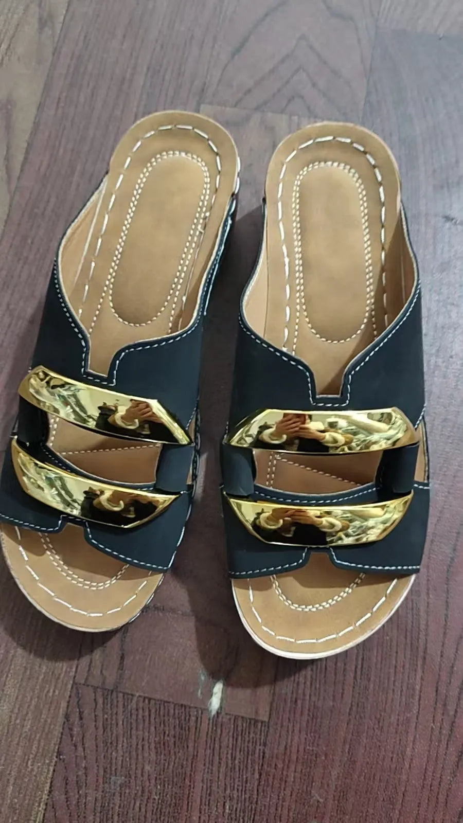 Roman style platform sandals in black with a flat heel and metal detail on the strap.