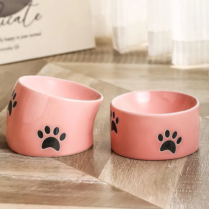 Ceramic cat bowl with high foot and cat's paw base in an oblique mouth design.