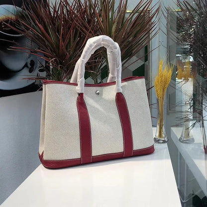 Genuine leather and canvas women's tote bucket bag in black, shown with a soft carry handle.