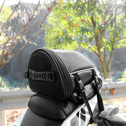 Black waterproof motorcycle tail bag with reflective stripe, showing multiple pockets and a carrying strap.