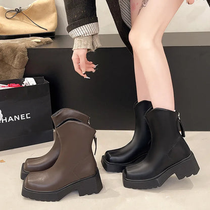 Women's black platform Martin ankle boots with square toe and back zip on a white background.
