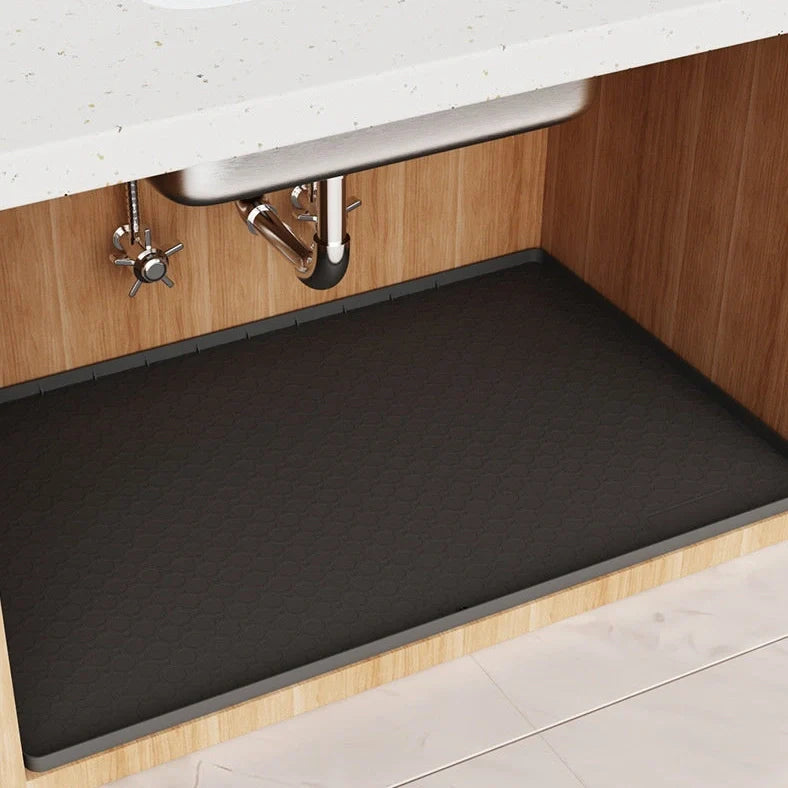 Grey silicone sink mat measuring 864mm by 558mm protecting kitchen cabinet from water damage