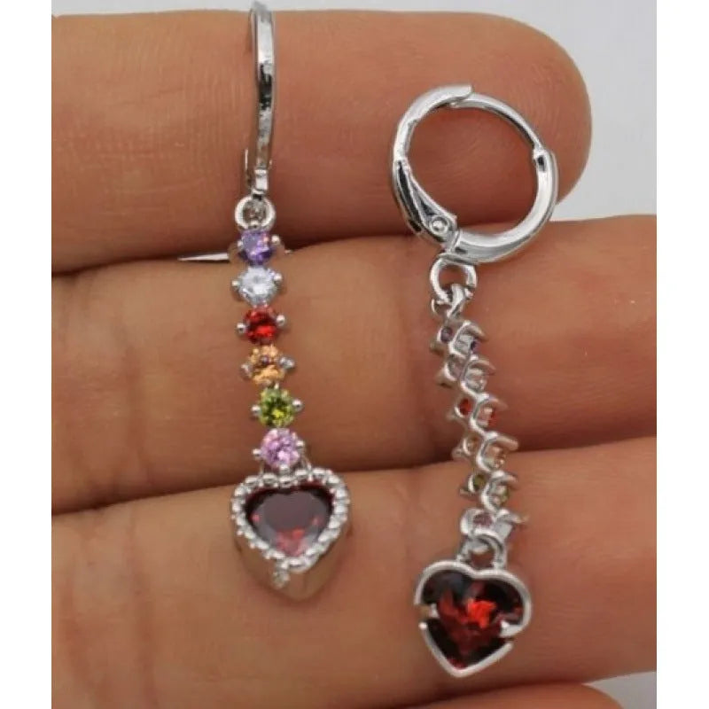 Women's gold and silver heart-shaped alloy drop earrings on a plain background.