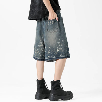 Retro blue denim shorts for men with ripped details and splash ink pattern on a straight cut.