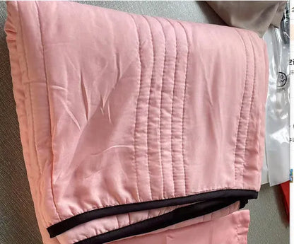 Lightweight plain coloured polyester summer quilt on a bed