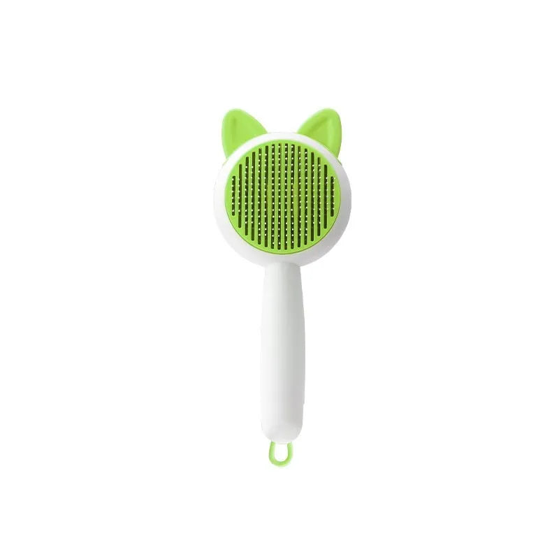 Greenish white pet grooming brush with stainless steel teeth, a push-button, and orange massage beads on the handle.