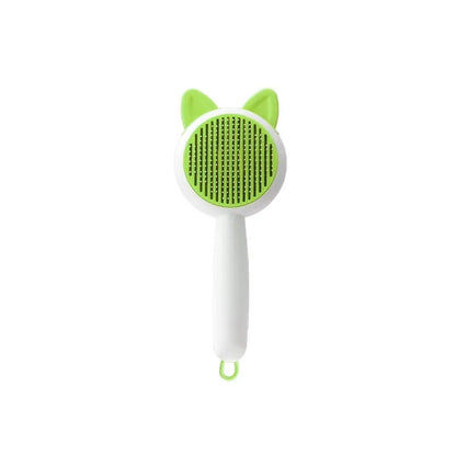 Greenish white pet grooming brush with stainless steel teeth, a push-button, and orange massage beads on the handle.