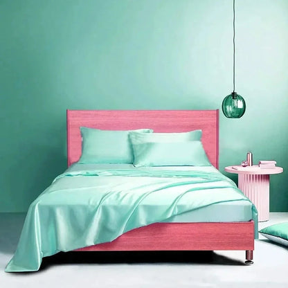 Navy blue floral pattern silk bedding set with quilt cover, fitted sheet, and two pillowcases on bed