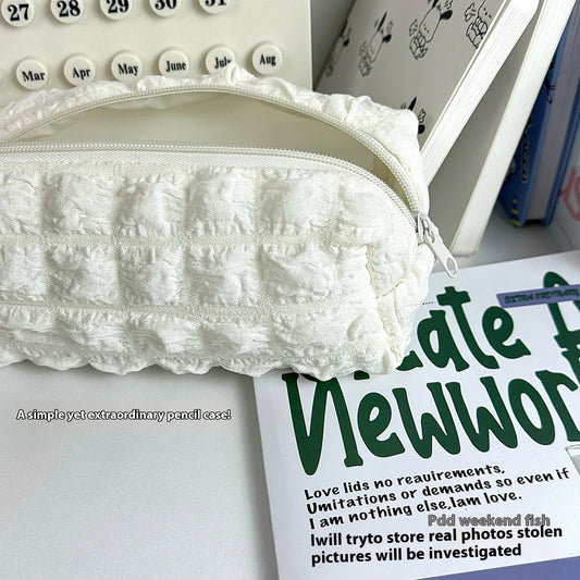 Beige and black fabric pencil case with padded cream puff design measuring 20cm length