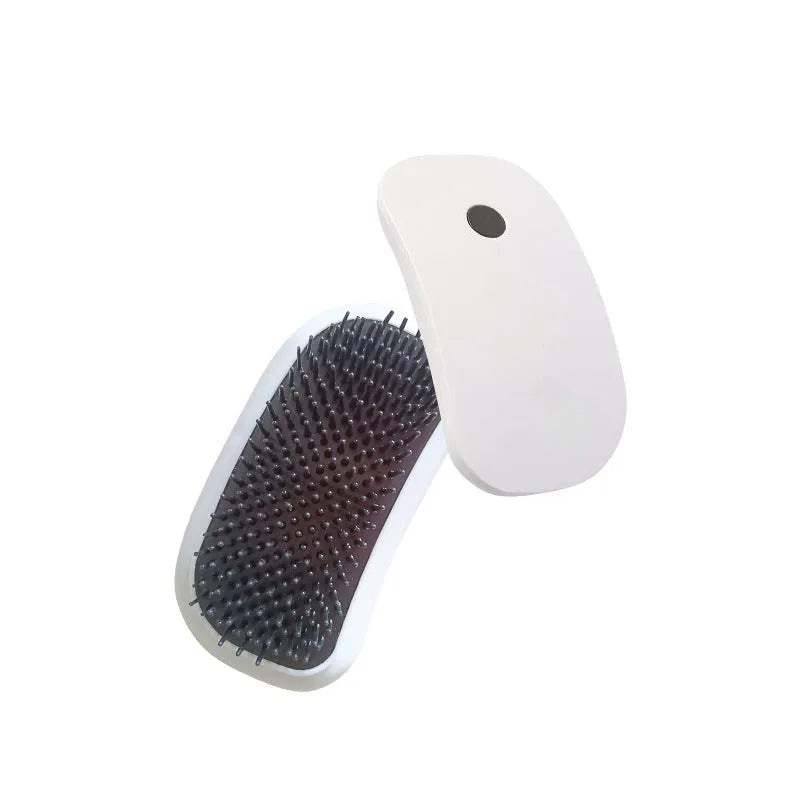 Pink Fuigarry handheld electric pet brush with soft teeth, placed on a carpet next to a cat.