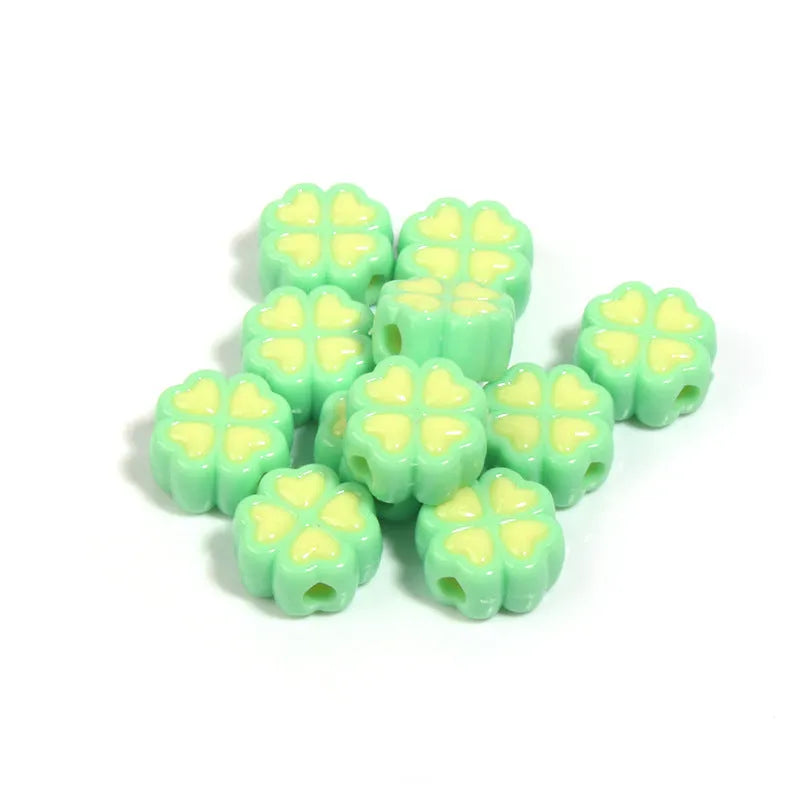 Assorted frosted acrylic four-leaf clover shaped beads in pink, green, and yellow, 15mm diameter.