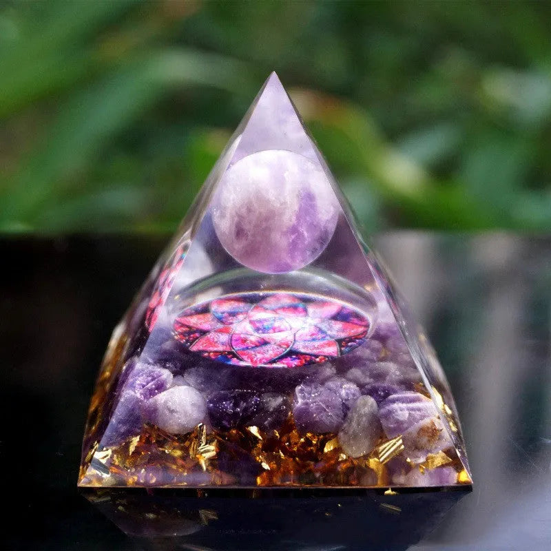 A small 6cm clear epoxy resin pyramid ornament containing pieces of natural crystal gravel on a flat surface.