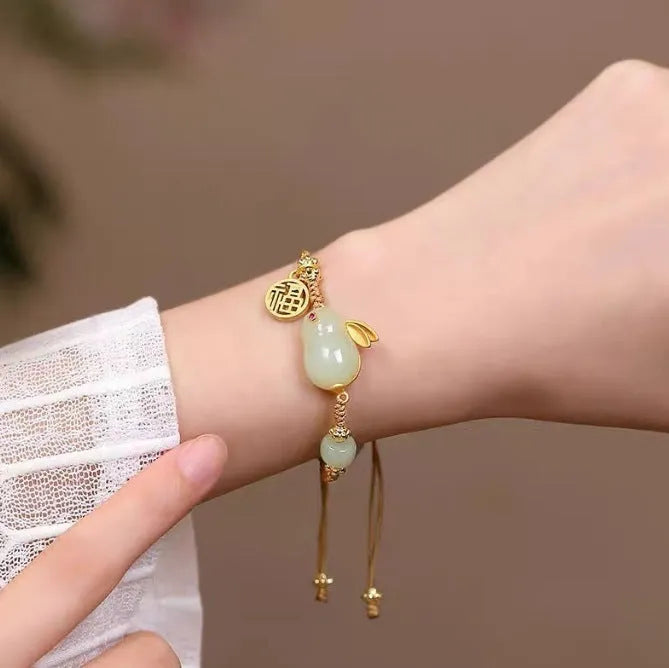 Hetian jade geometric rabbit charm on a yellow string bracelet for women.