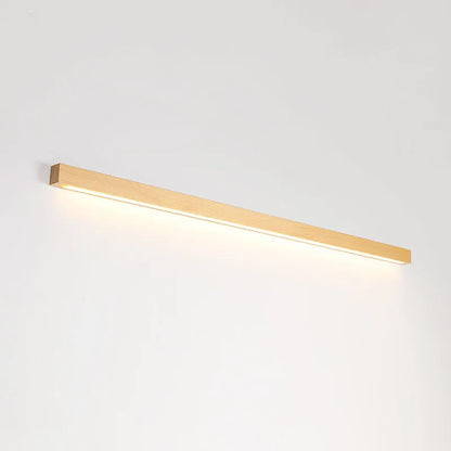 A long, slim walnut-coloured wooden strip wall lamp with an integrated LED light source mounted on a plain wall.