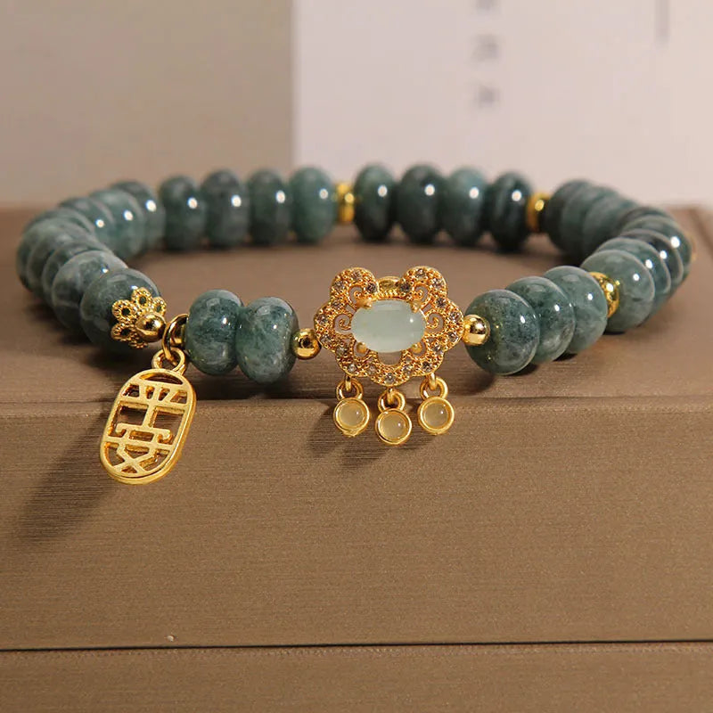 Close-up of a women's bracelet with green emerald jade abacus beads and a silver alloy safety lock clasp.