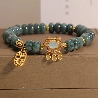 Close-up of a women's bracelet with green emerald jade abacus beads and a silver alloy safety lock clasp.