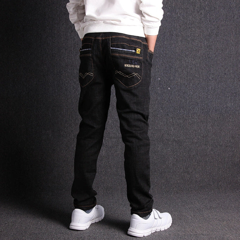 Boys' black micro-stretch cotton jeans showing 4-way flexibility and middle waist design