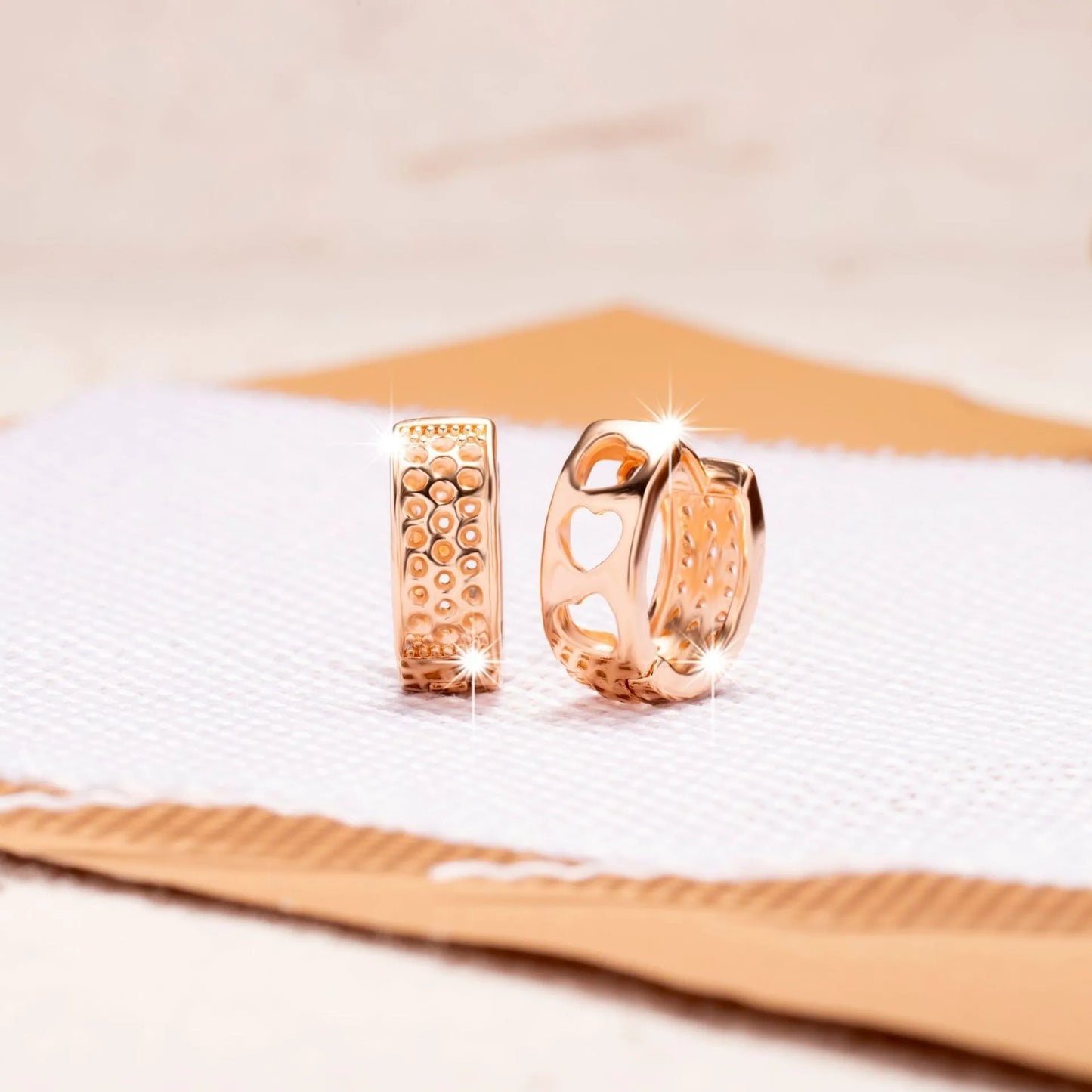 Rose gold electroplated earrings with 2.5cm circular design and three heart-shaped cut-outs