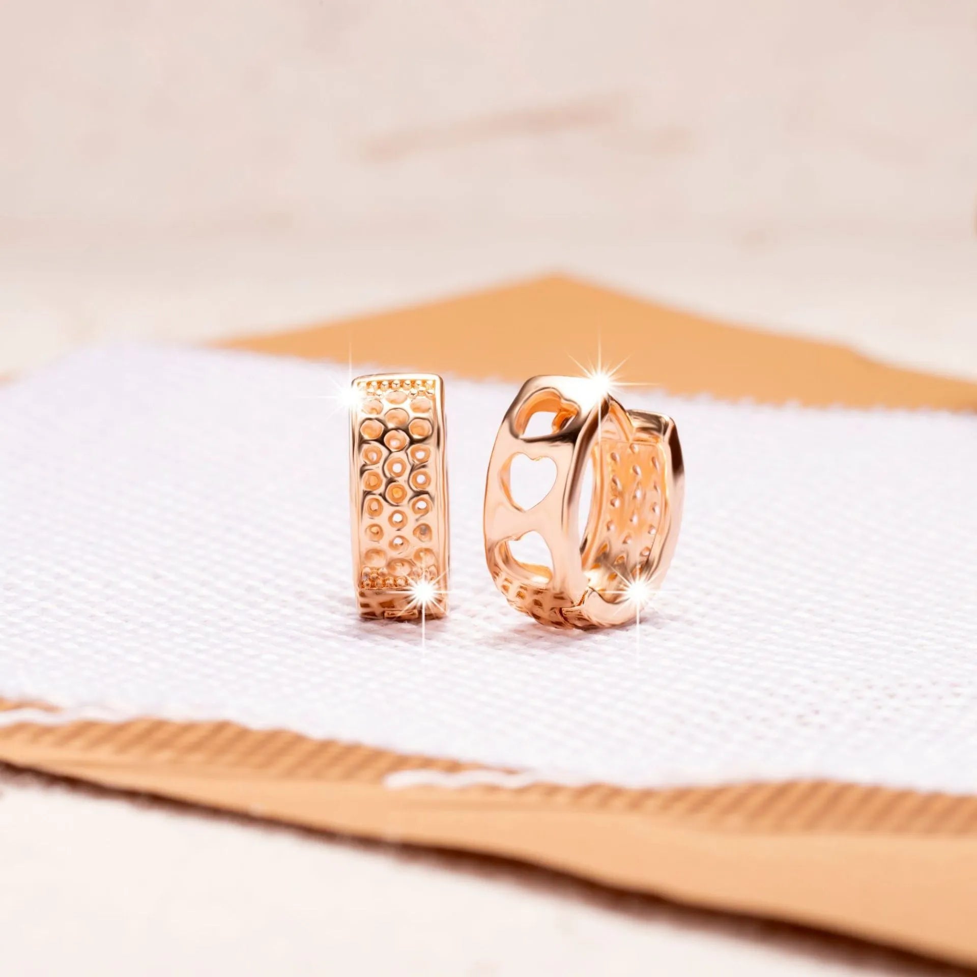 Rose gold electroplated earrings with 2.5cm circular design and three heart-shaped cut-outs
