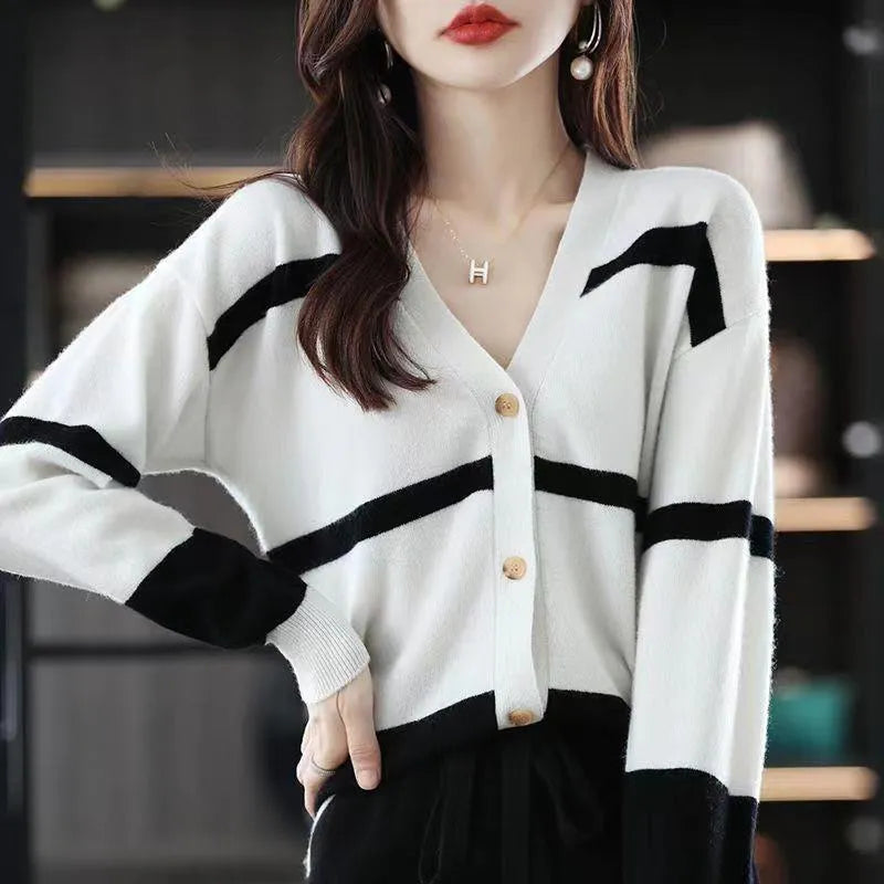 Women's black and white striped V-neck cardigan with buttons, showing a textured 3D knit pattern.