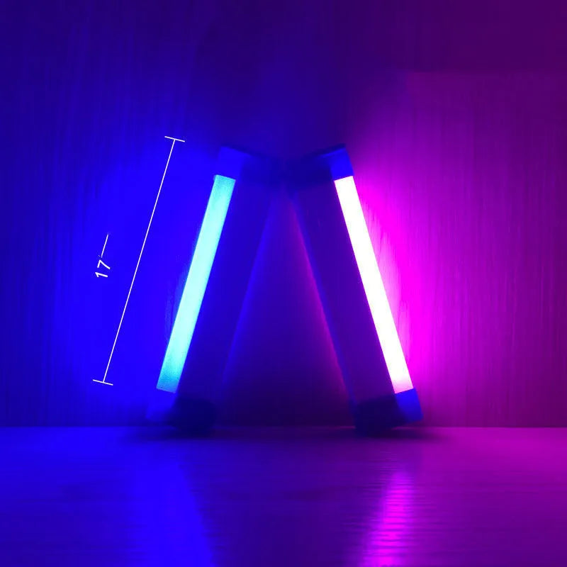 Blue rechargeable LED light tube with USB plug and push-button switch on a dark surface