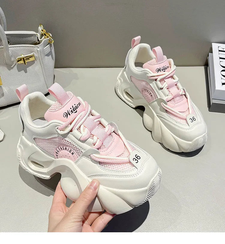 Women's pink sneakers with cross straps, thick sole, and mesh lining on a white background
