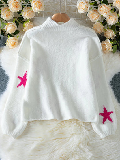 White women's turtleneck pullover with a black star pattern, loose fit, and long sleeves.