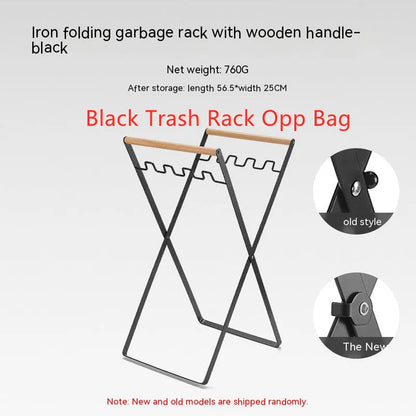 Black iron folding trash rack with wooden handles mounted on a wall holding a recycling bag.
