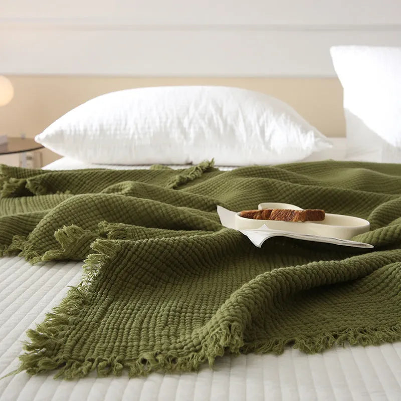 Four-layer gauze tassel blanket in cotton, showing tassel edges and textured fabric, available in multiple colours and sizes