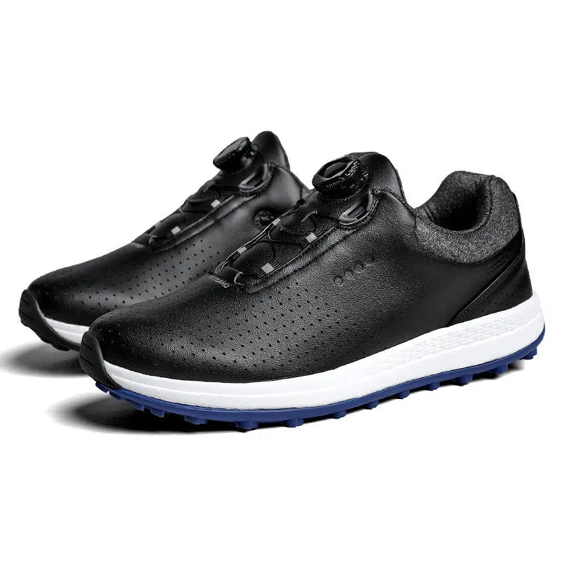Men's white and black casual golf shoes with perforated upper and low-top design on a grass surface.