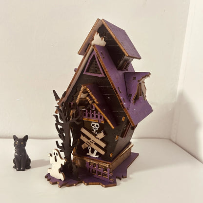 Wooden haunted house table decoration measuring 14x10.5x19cm with luminous finish and candlestick holder function