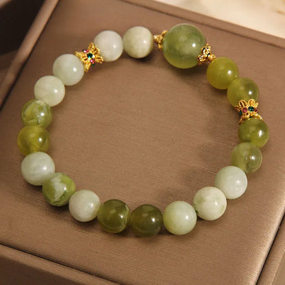 Original design women's bracelet with a green Xiuyan jade stone on wrist.