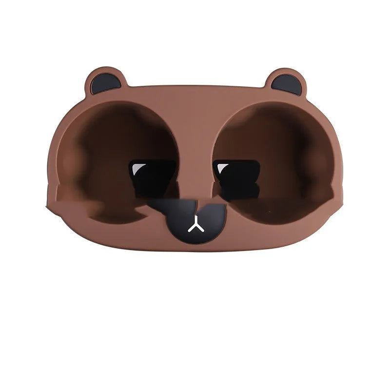 Flexible grey silicone car cup holder insert with a raised cartoon animal design for the centre console.