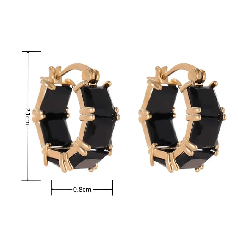 A pair of geometric U-shaped copper earrings with a round zircon stone in a gold-coloured setting.