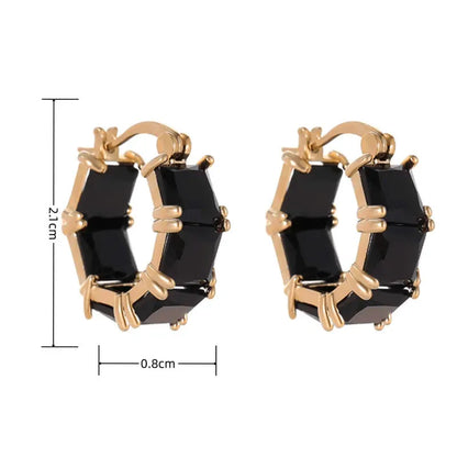 A pair of geometric U-shaped copper earrings with a round zircon stone in a gold-coloured setting.