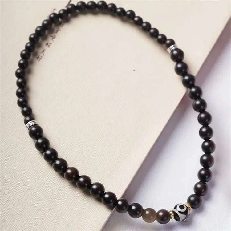 Dark ebony wood bracelet with Tibetan bead design showing two brown circles, 8mm wide unisex accessory