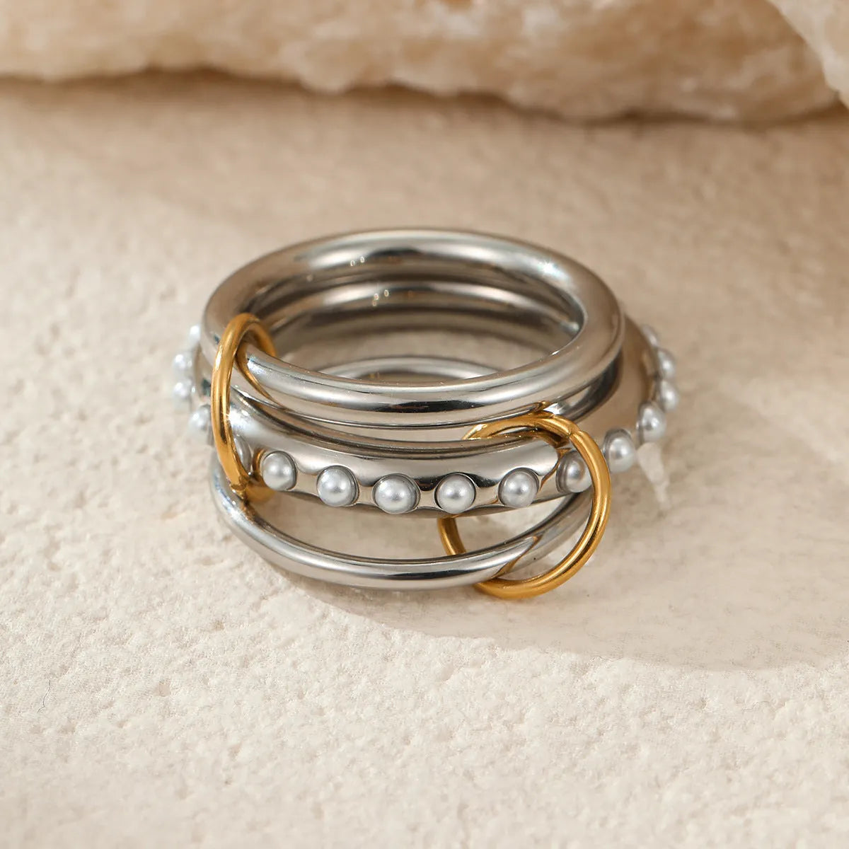 Stacked stainless steel rings with 18K gold plating in three colour variations, exaggerated hand jewellery designs