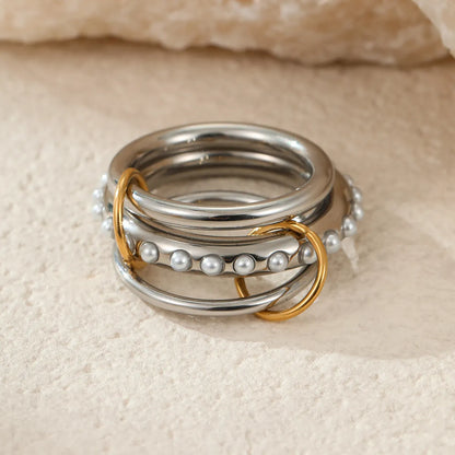 Stacked stainless steel rings with 18K gold plating in three colour variations, exaggerated hand jewellery designs