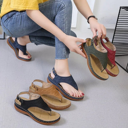 Women's wedge heel flip flop sandals in black with adjustable back strap on a light background