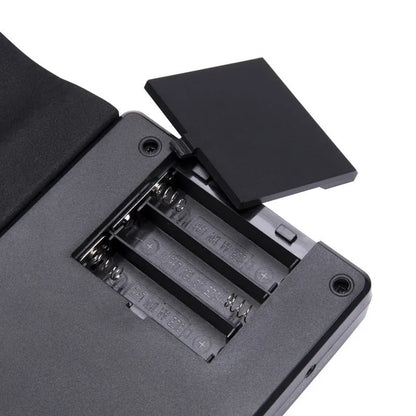 49-key folding electronic keyboard in gloss black with built-in speaker, unfolded to show silicone rubber keys and ABS plastic control panel