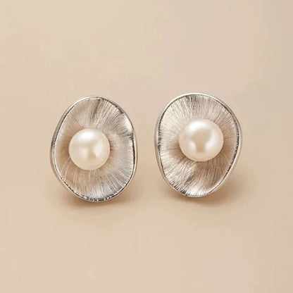 A pair of gold-coloured geometric sterling silver stud earrings with white pearl accents on a white background.