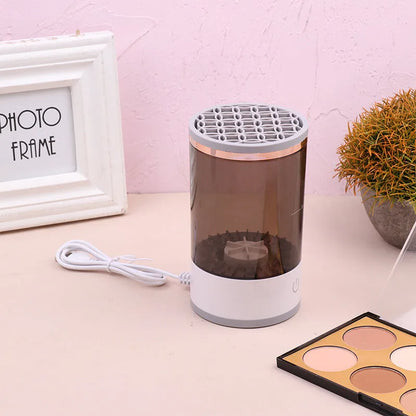 Grey and white portable electric makeup brush cleaner with USB charging cable.